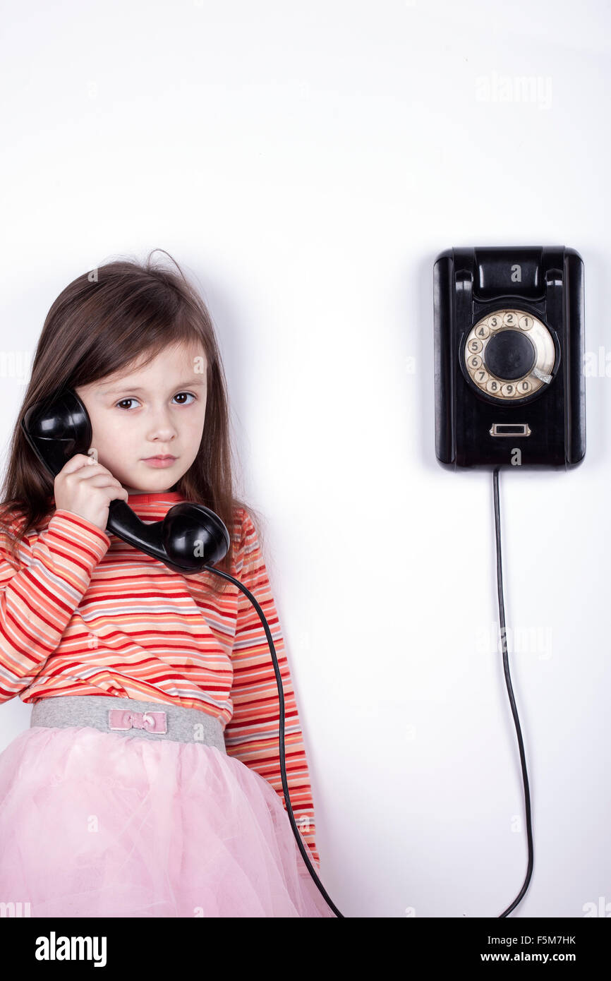 Serious sad child talking on phone, white background Stock Photo