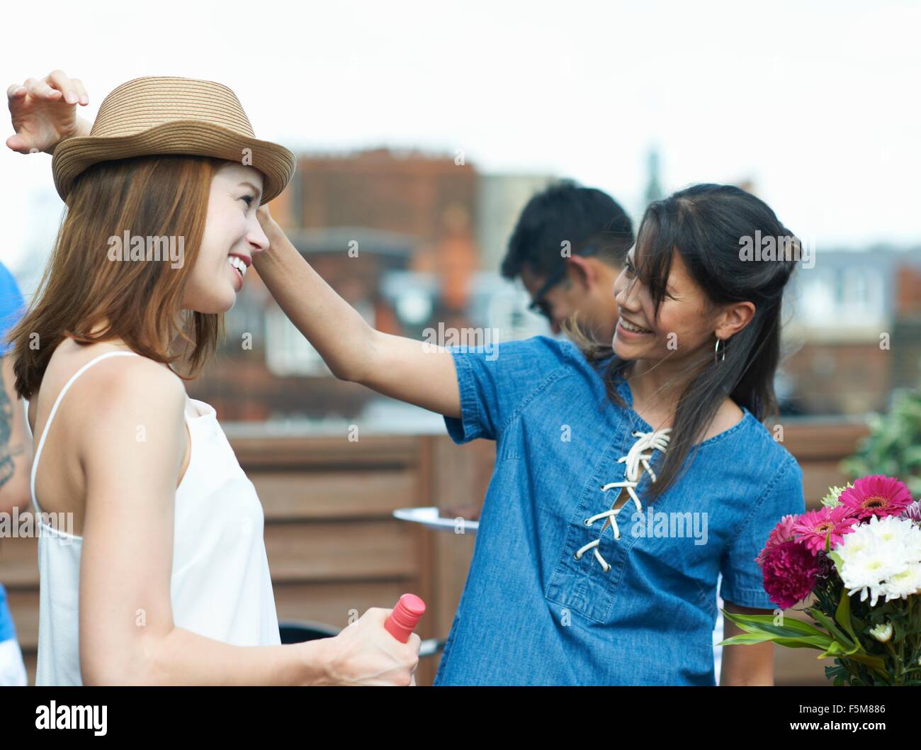 Female friends chatting at rooftop party Stock Photo
