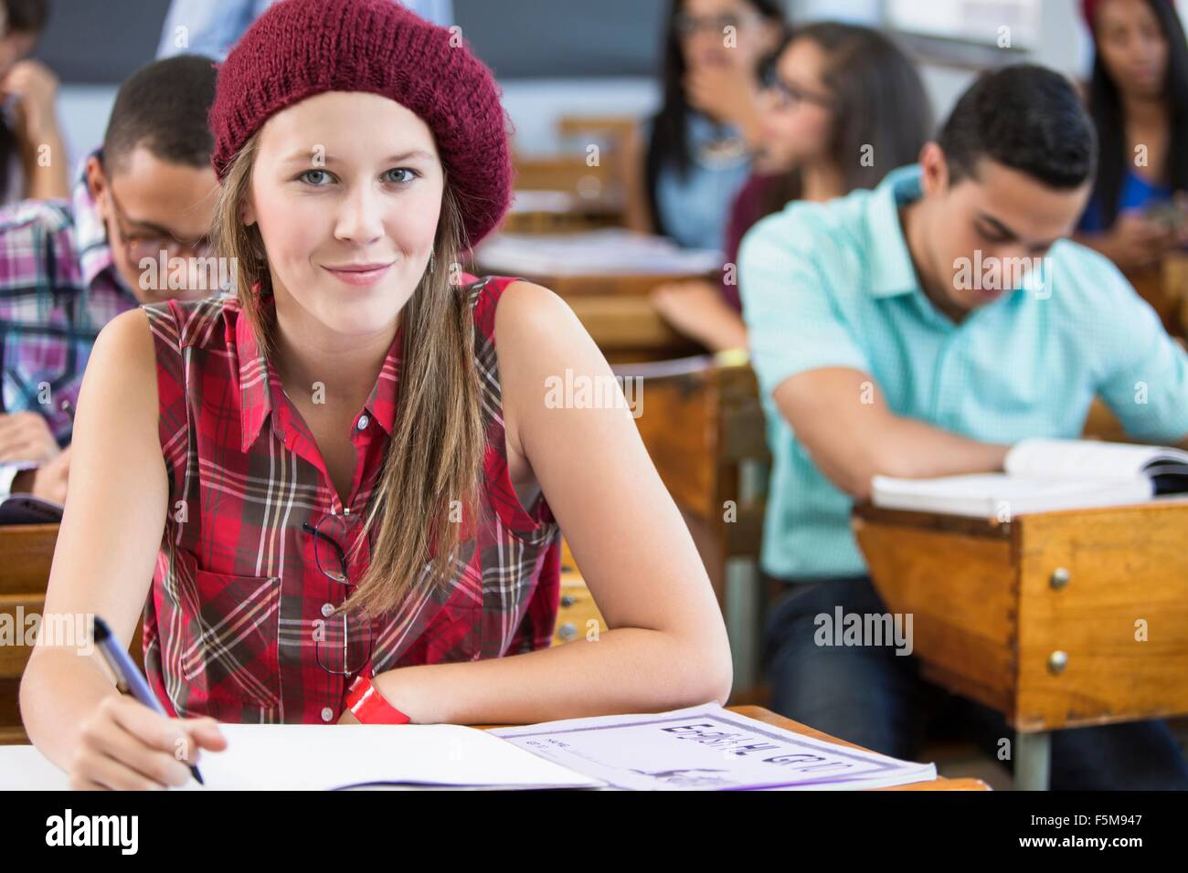 Portrait of female student, sitting at desk in classroom Stock Photo ...