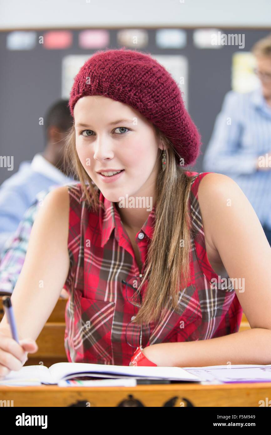 Portrait of female student, sitting at desk in classroom Stock Photo ...