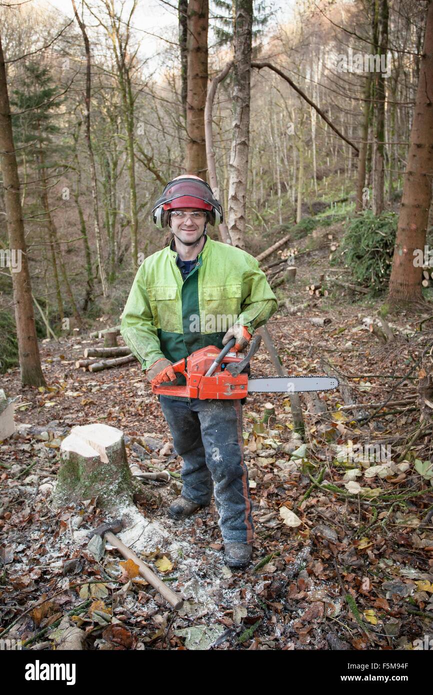 Conservationist working in a reserve to remove non-native conifer trees for natural forest restoration Stock Photo
