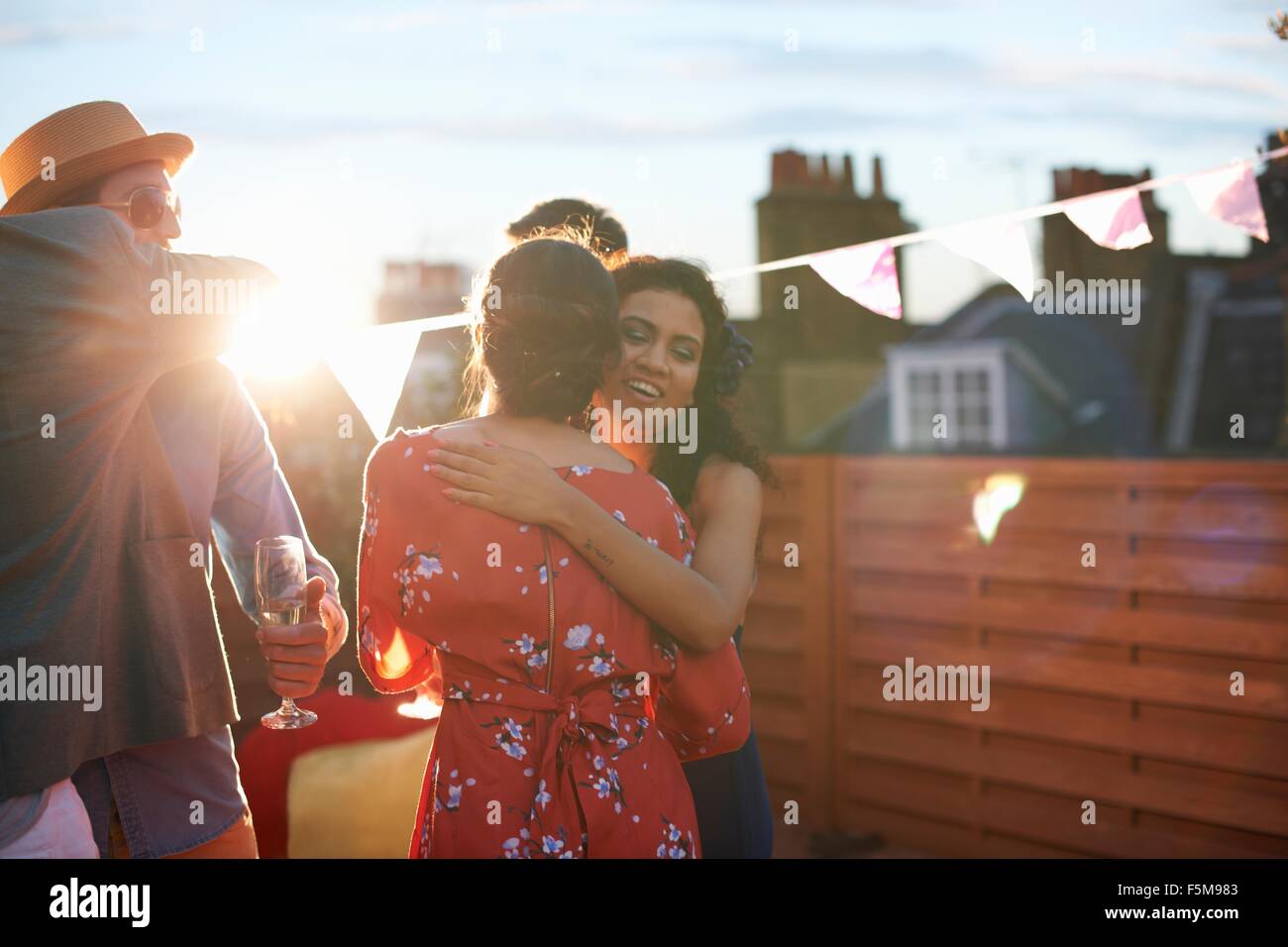 Friends congratulating couple at early evening engagement party Stock Photo