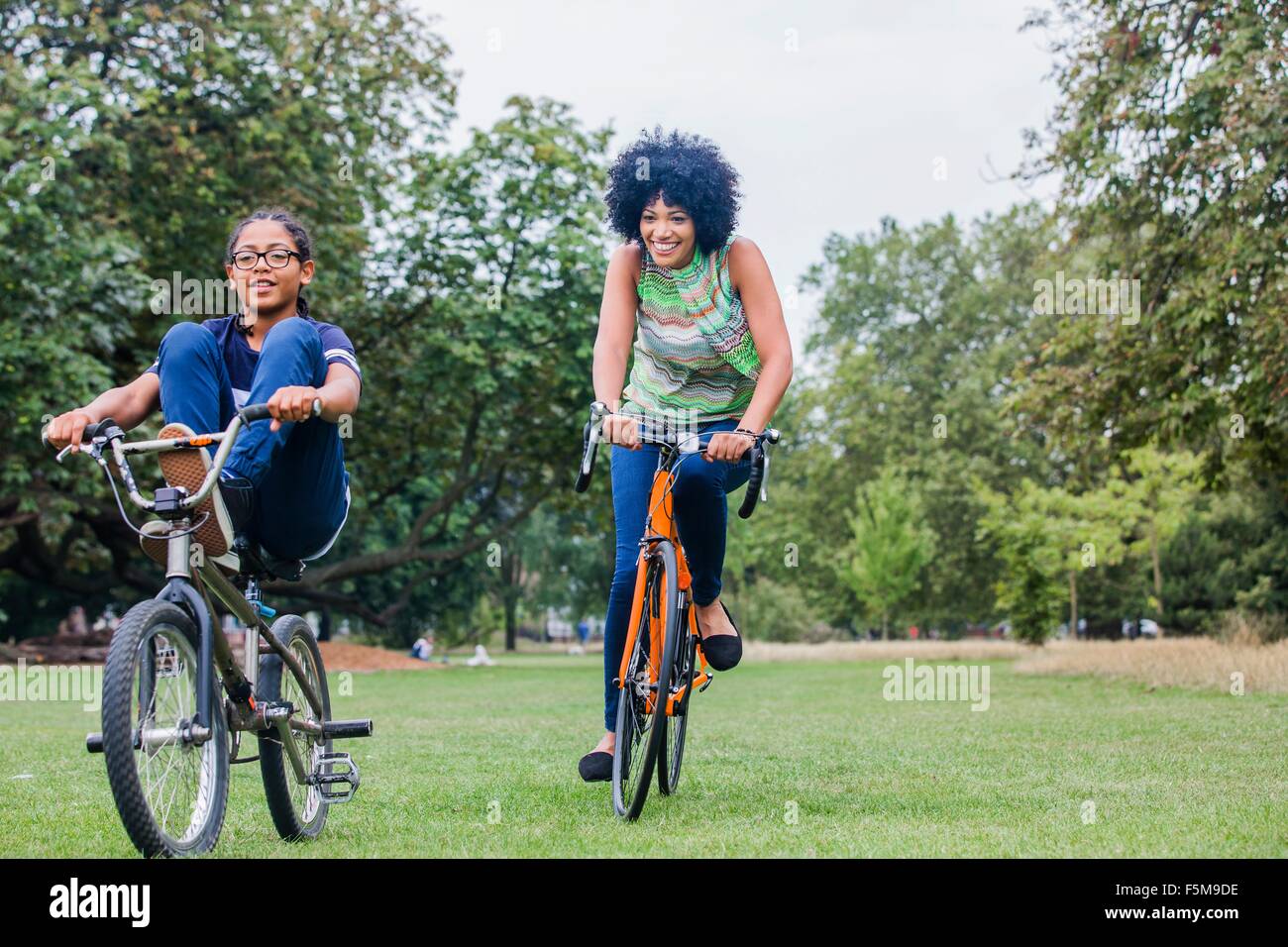 Front view of mother and son riding on bicycles smiling Stock Photo