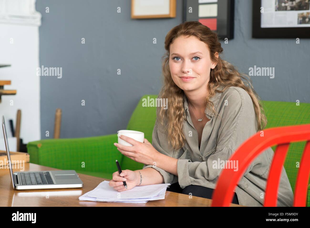 Portrait of young female designer on office sofa Stock Photo