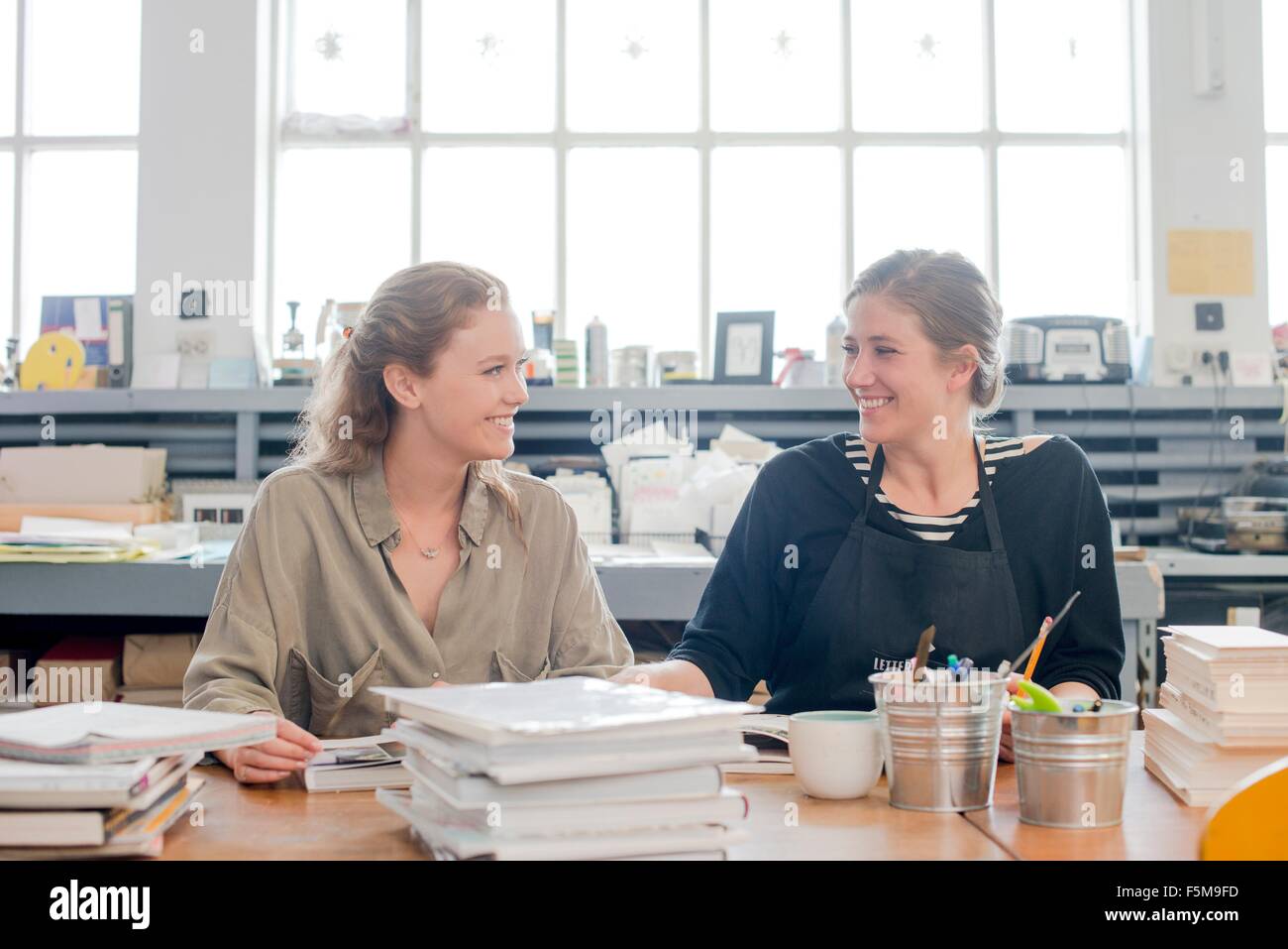 Female print designers talking in workshop Stock Photo