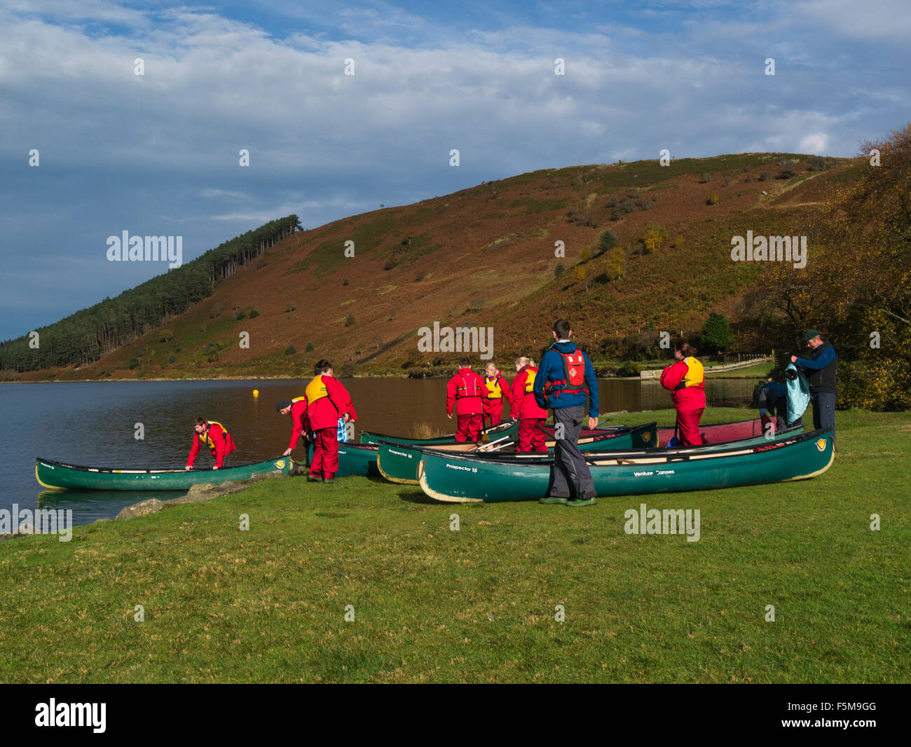 Group students preparing to canoe Llyn Gierionydd Conwy North Wales where northern edge of  Gwydyr Forest meets lower slopes of Carneddau mountains Stock Photo
