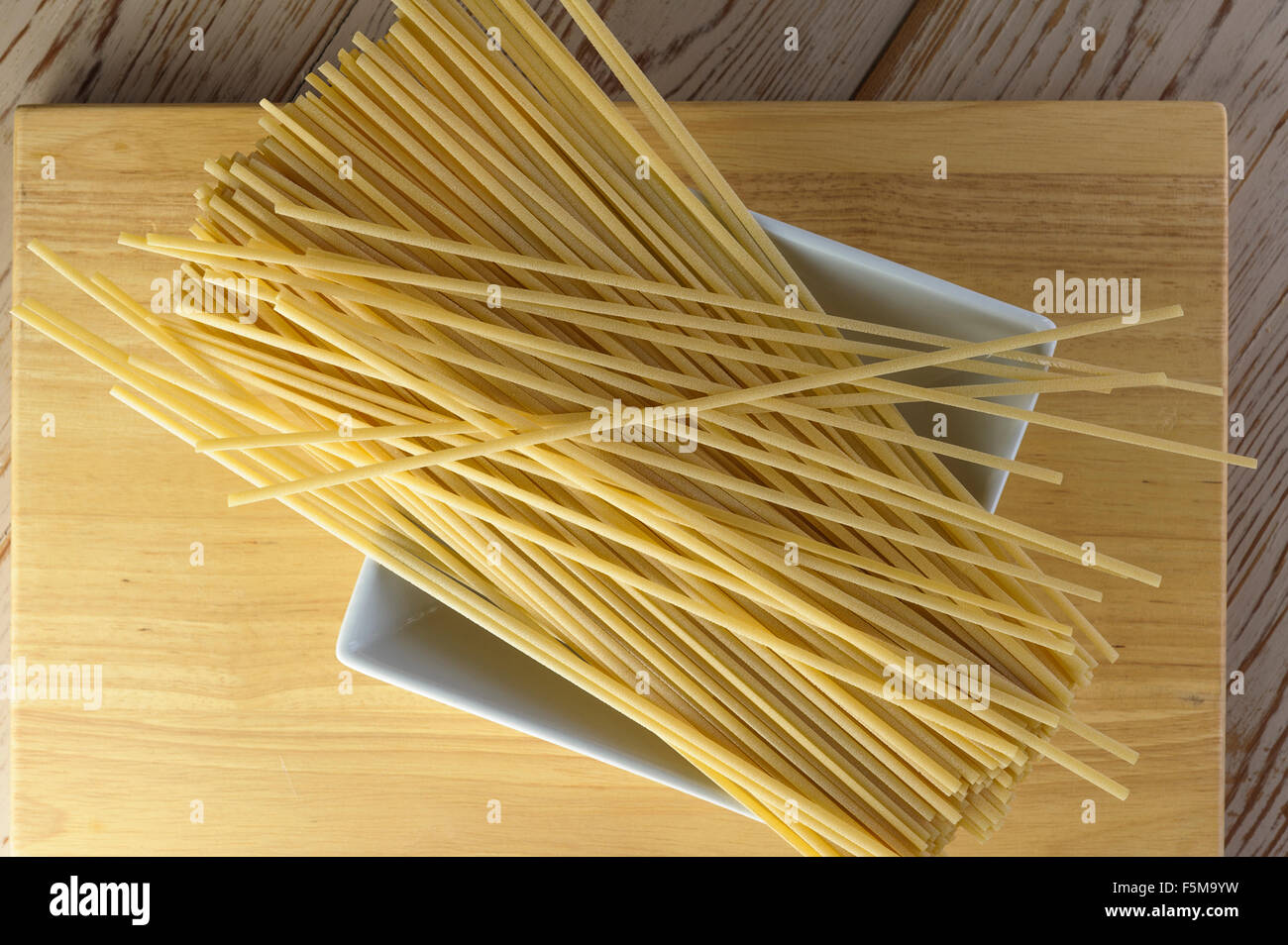 Uncooked linguine pasta resting on a white bowl Stock Photo Alamy