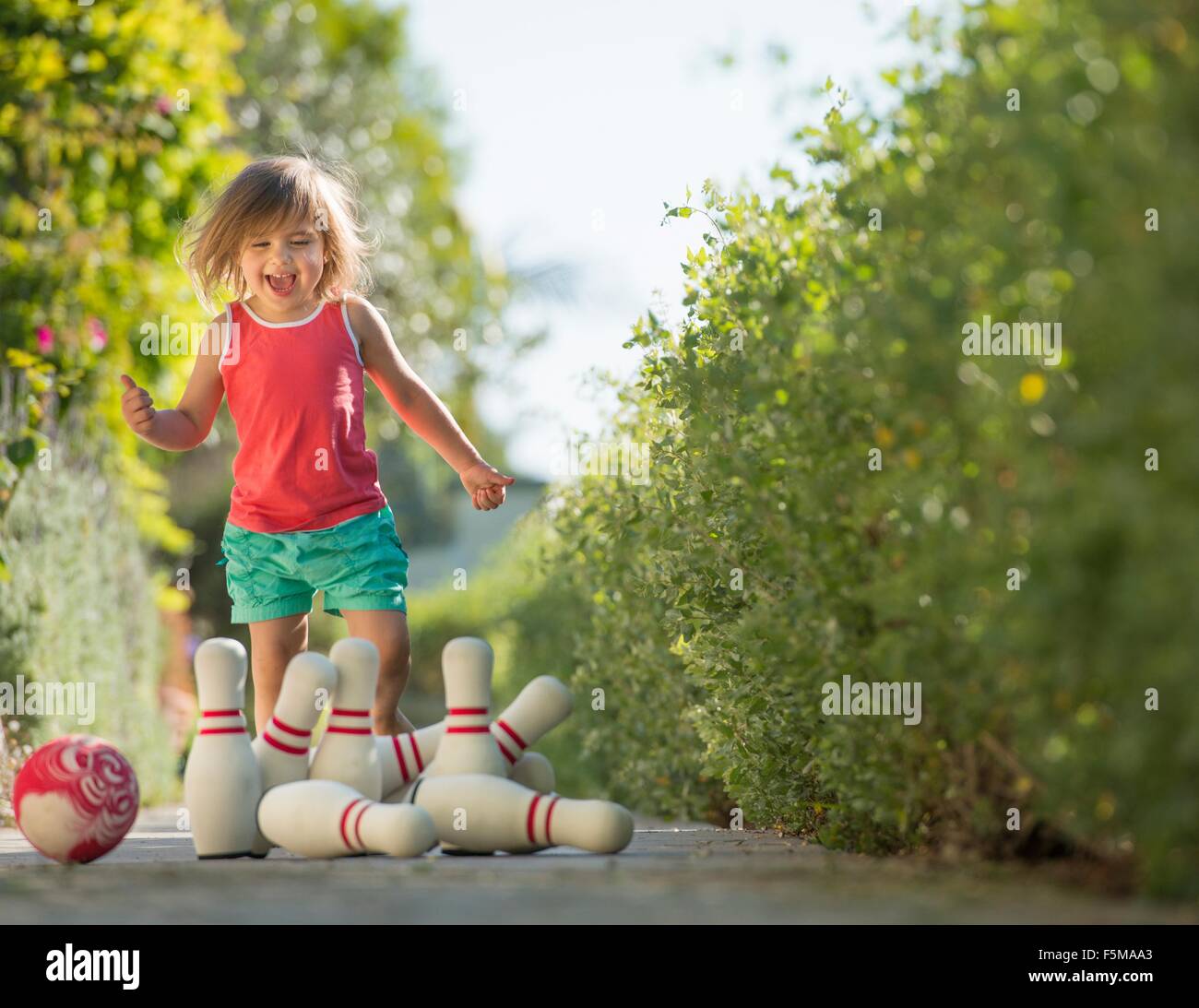 Young girl playing with skittles, outdoors Stock Photo