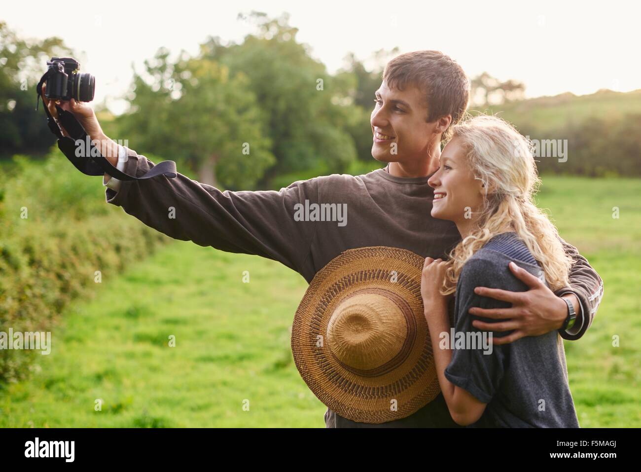 Young couple taking self portrait in rural field Stock Photo
