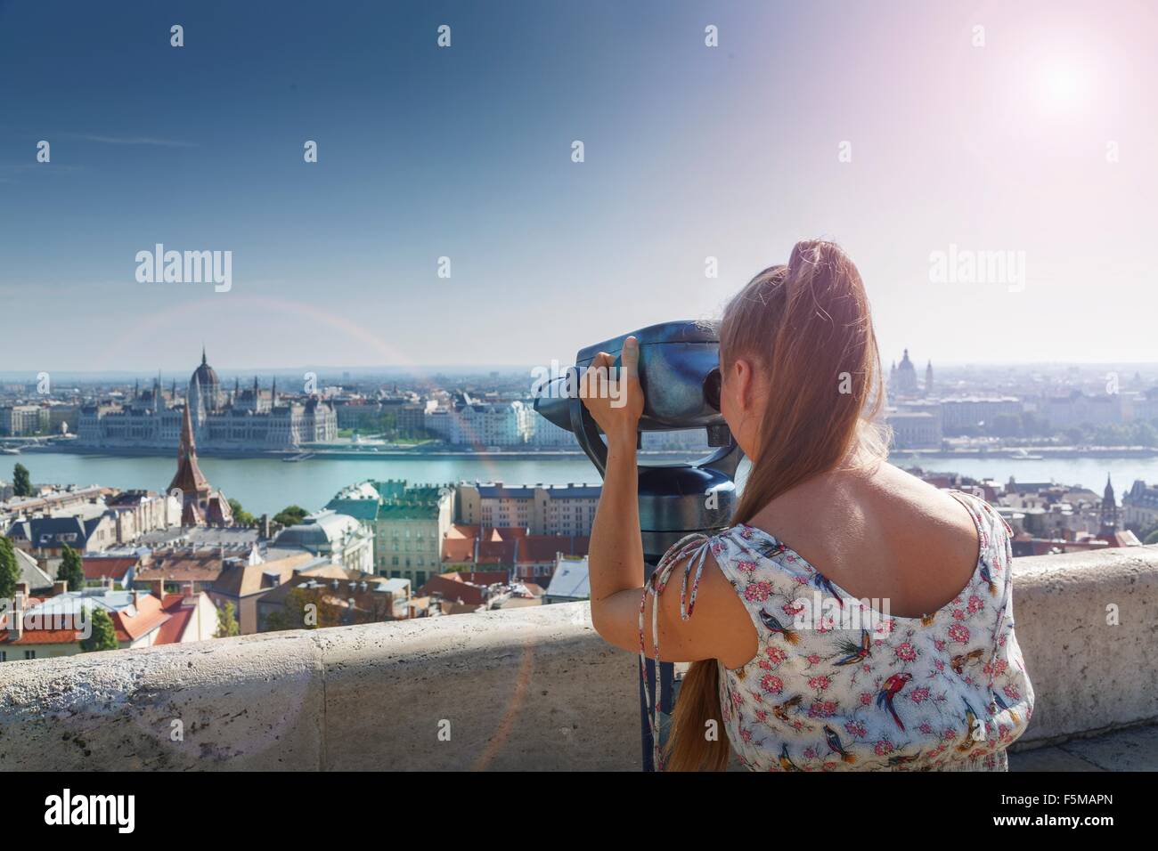 Mid adult woman using viewing binoculars, rear view, Budapest, Hungary Stock Photo