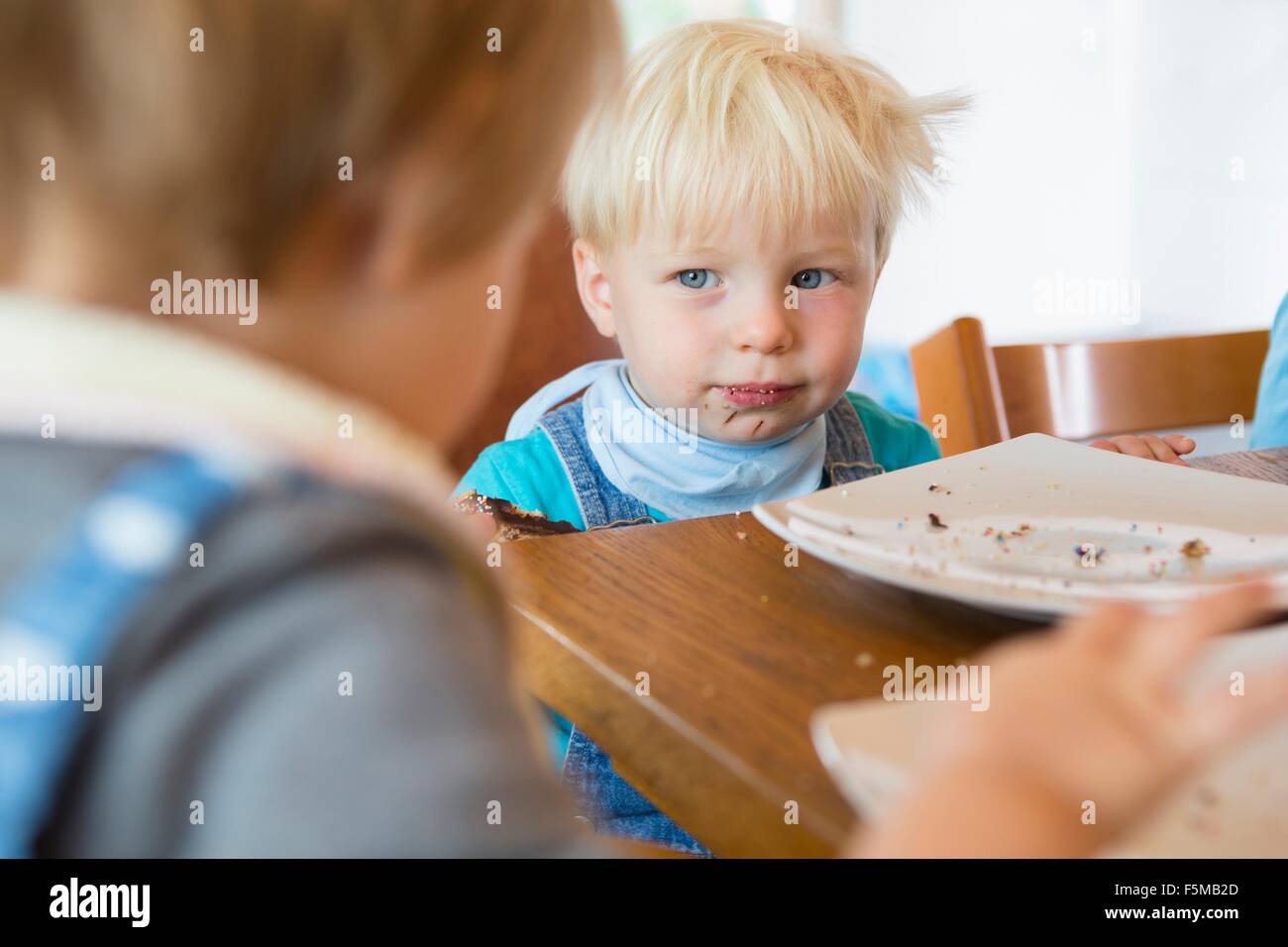 Male and female toddler at tea table Stock Photo