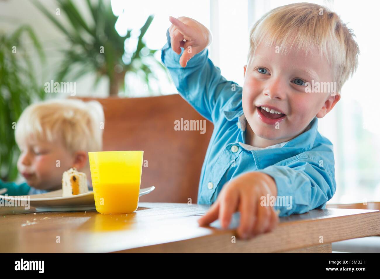 Boy and toddler brother at tea table Stock Photo
