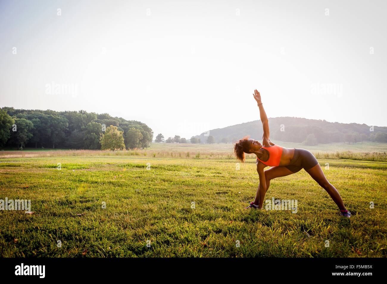 Young woman practicing yoga in rural park Stock Photo - Alamy