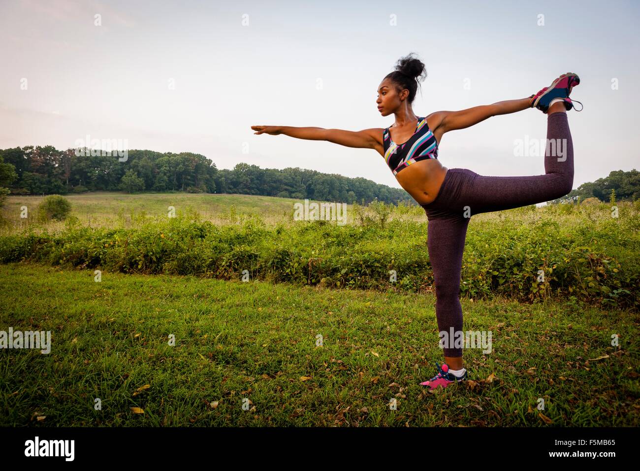 Young woman practicing yoga pose in rural park Stock Photo - Alamy