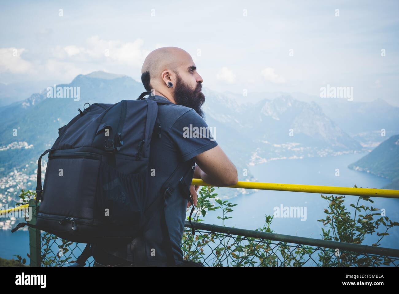 Mid adult man on balcony looking out at Lake Lugano, Switzerland Stock Photo