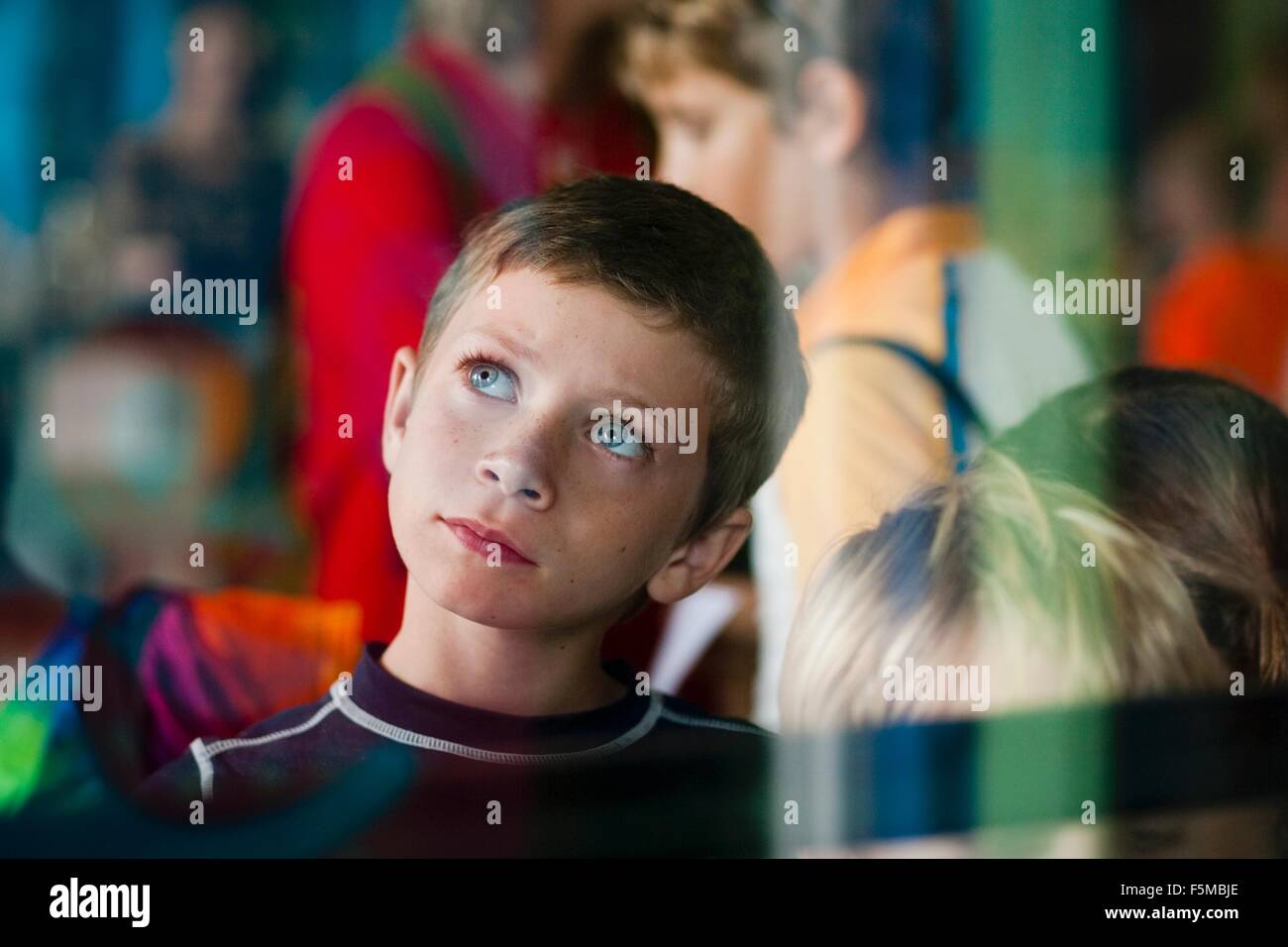 View through glass of young boy on outing looking up thoughtfully Stock Photo