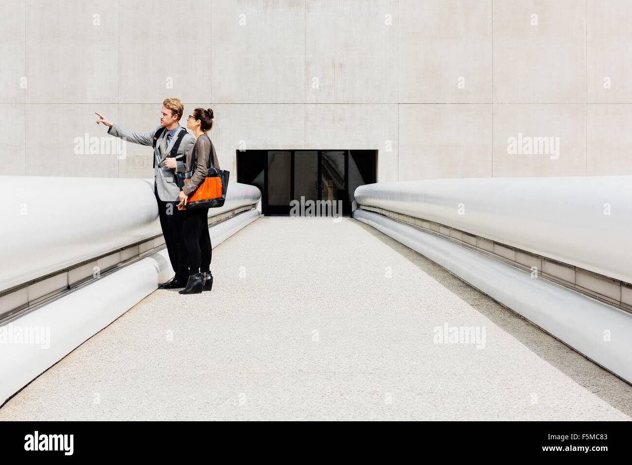 Businessman and woman talking on walkway Stock Photo