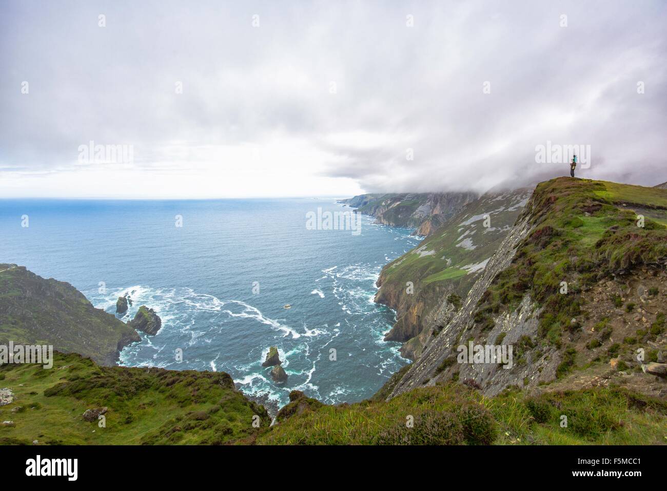 Daughter sitting on fathers shoulders looking at view from cliff, Slieve League, County Donegal, Ireland Stock Photo