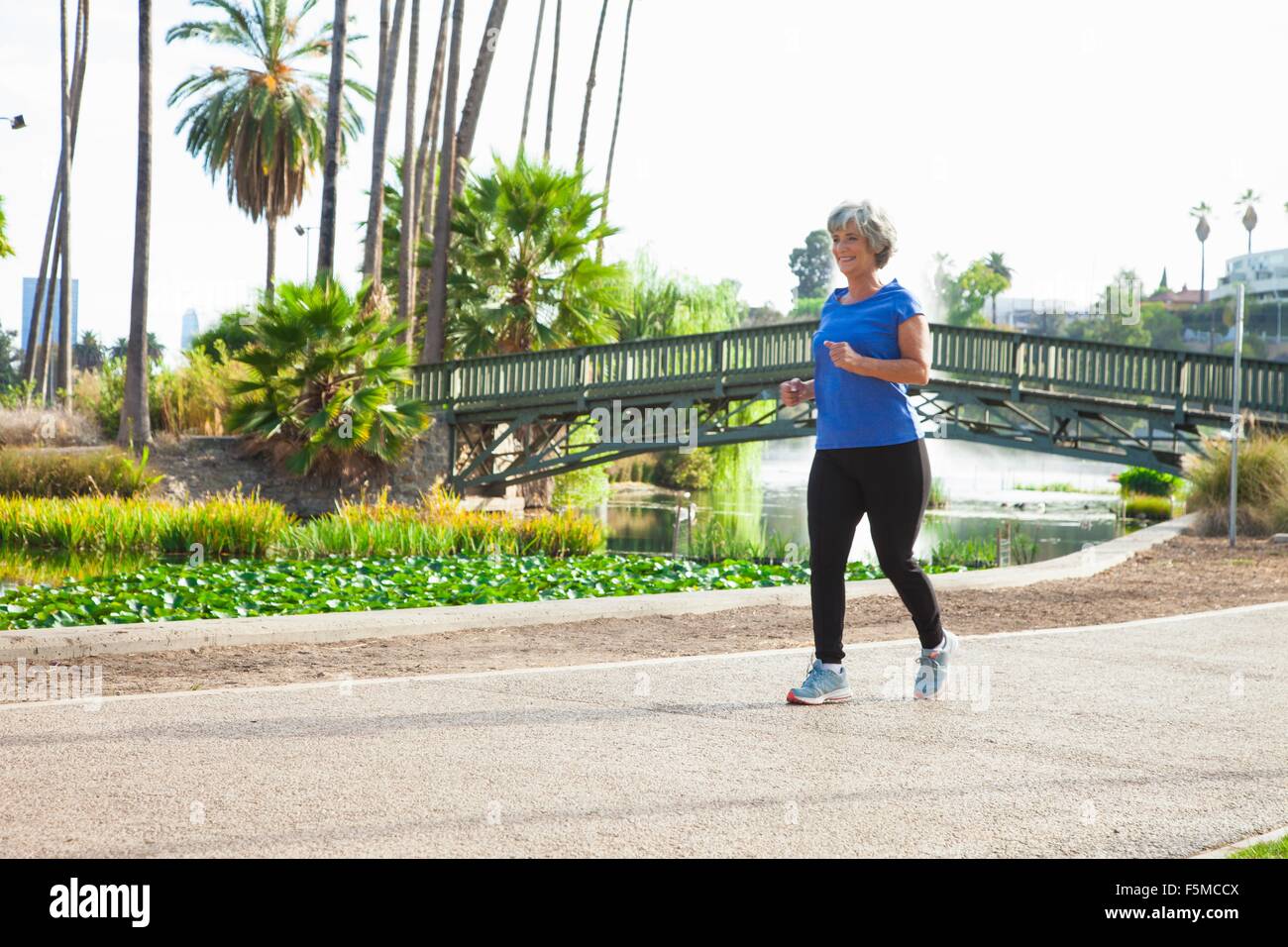 Mature woman jogging in park Stock Photo