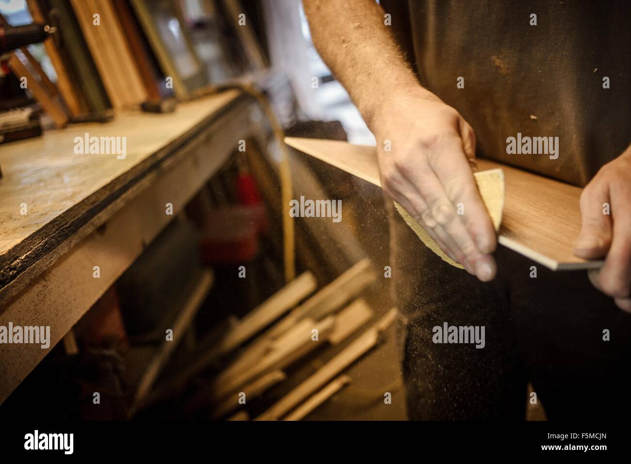 Wood artist in workshop, sanding wood, close-up Stock Photo
