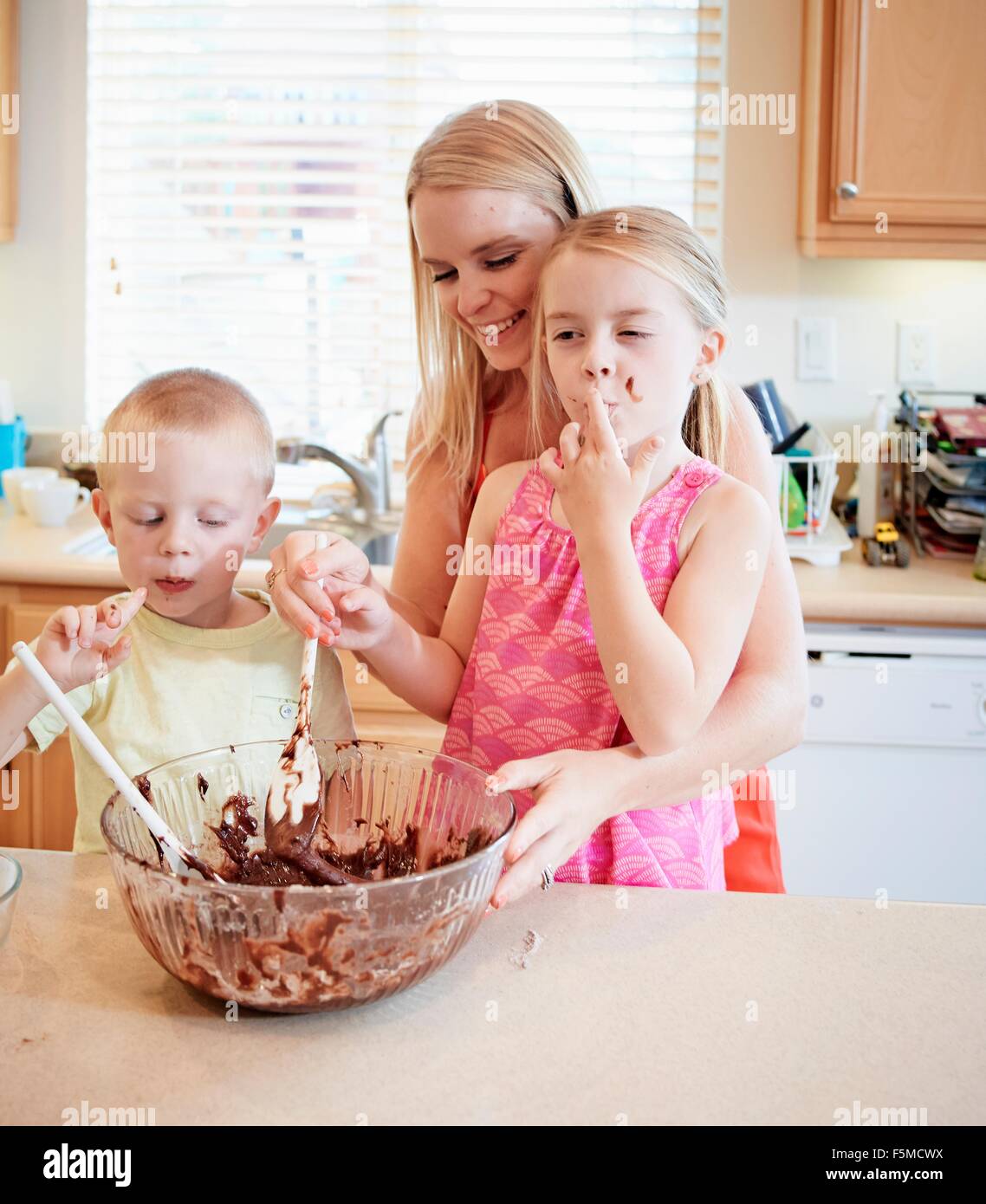 Family melting chocolate in mixing bowl Stock Photo