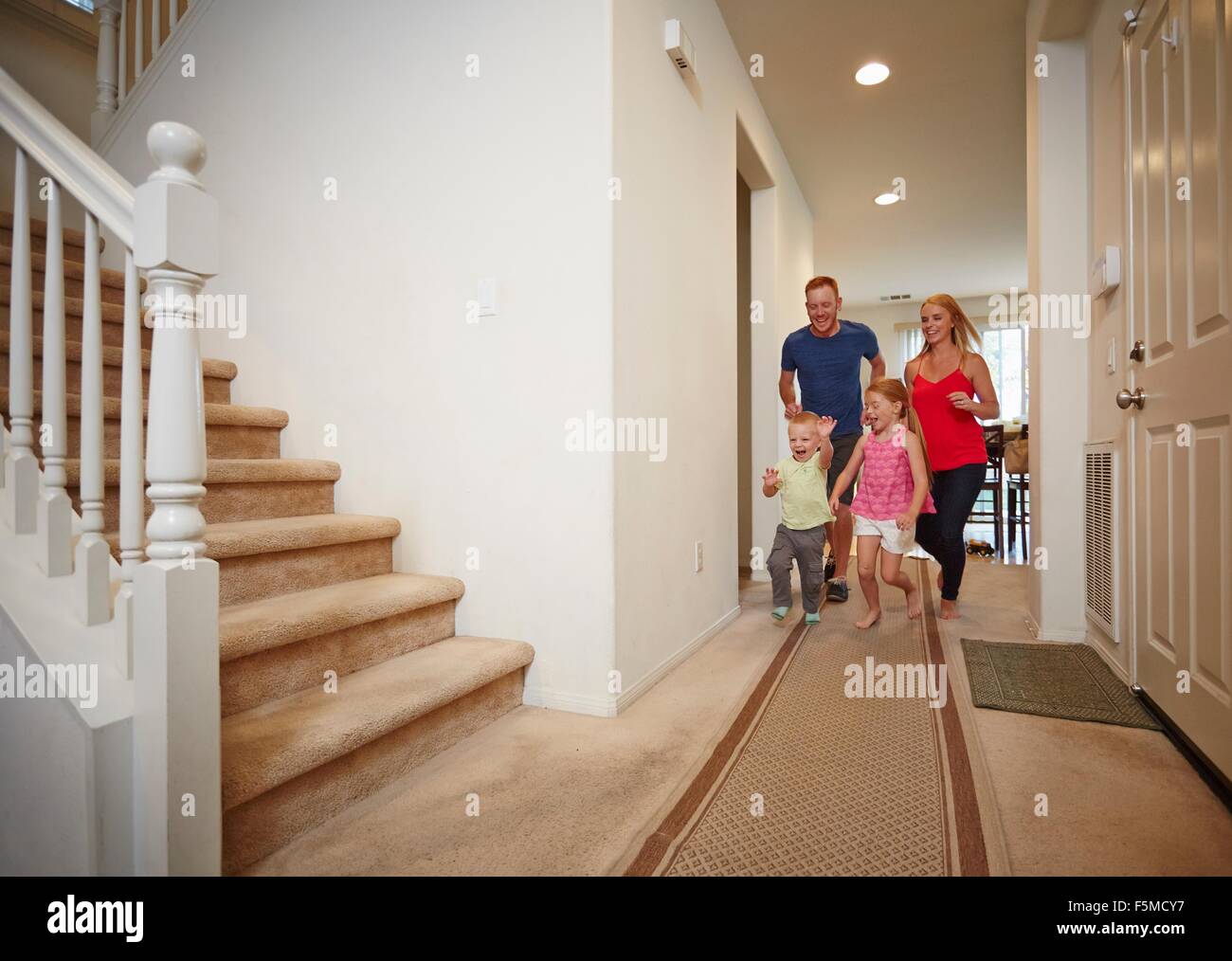 Family running in hallway at home Stock Photo