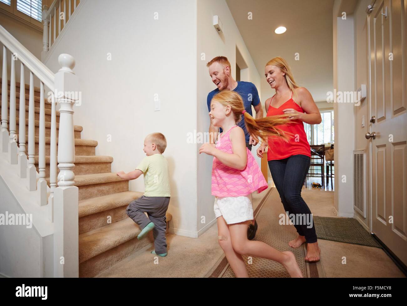 Family running up staircase at home Stock Photo