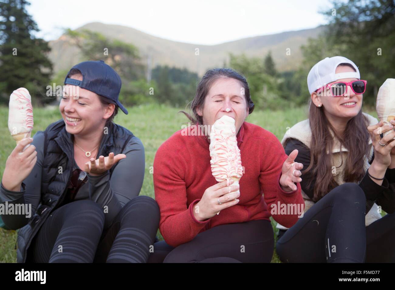 Hikers enjoying ice cream cone on grass, Lake Blanco, Washington, USA Stock Photo