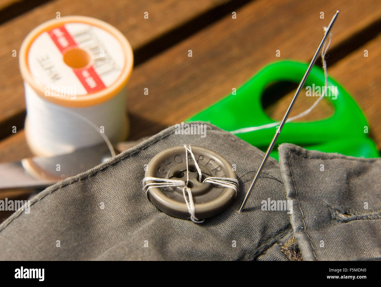 Sewing on button Stock Photo