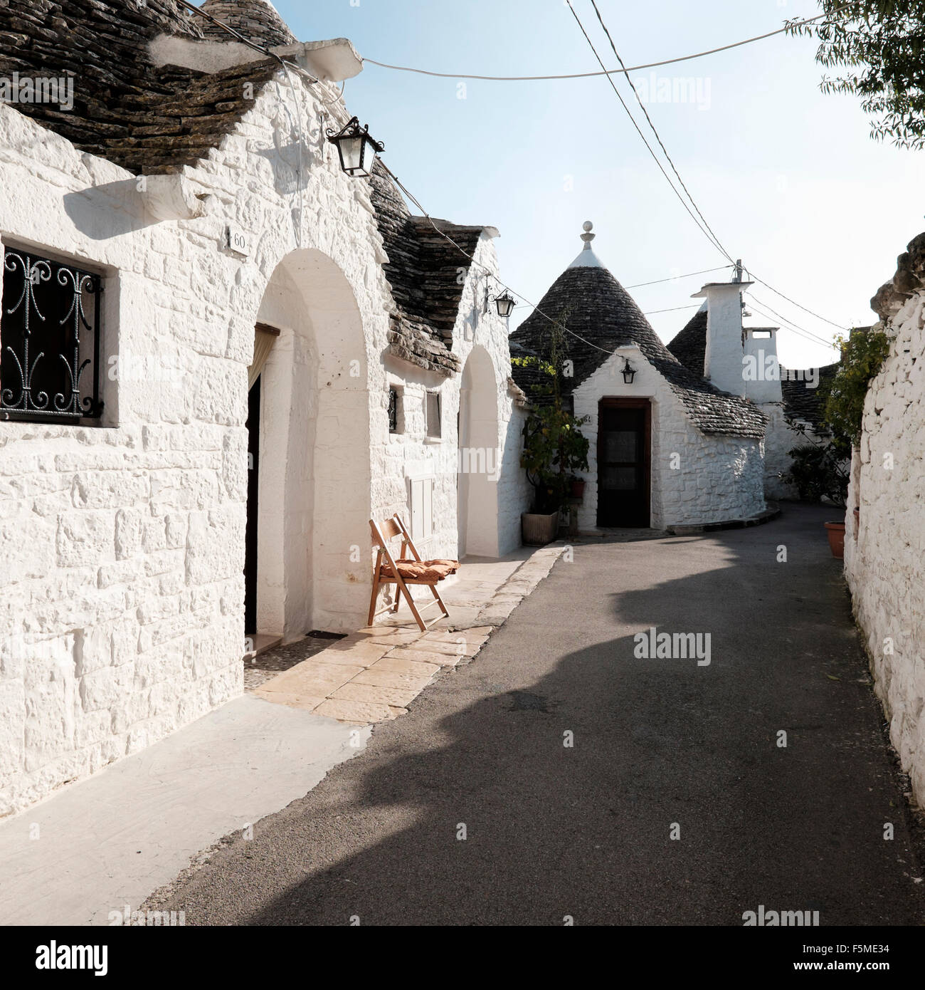 An empty seat in the street outside one of the Trulli of Alberobello, Bari Province, Apuglia, Italy Stock Photo