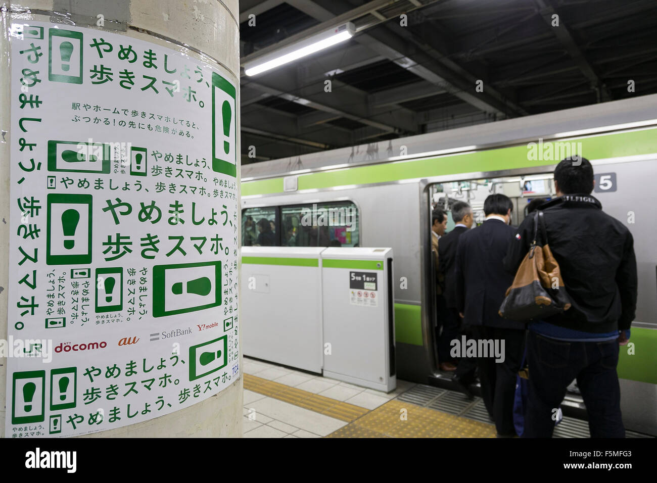 Japanese Commuters Walk Past A Poster About The Dangers Of Using Mobile Devices Whilst Walking At Tamachi Station On November 6 15 Tokyo Japan Jr East Japan Railway Company Has Launched A