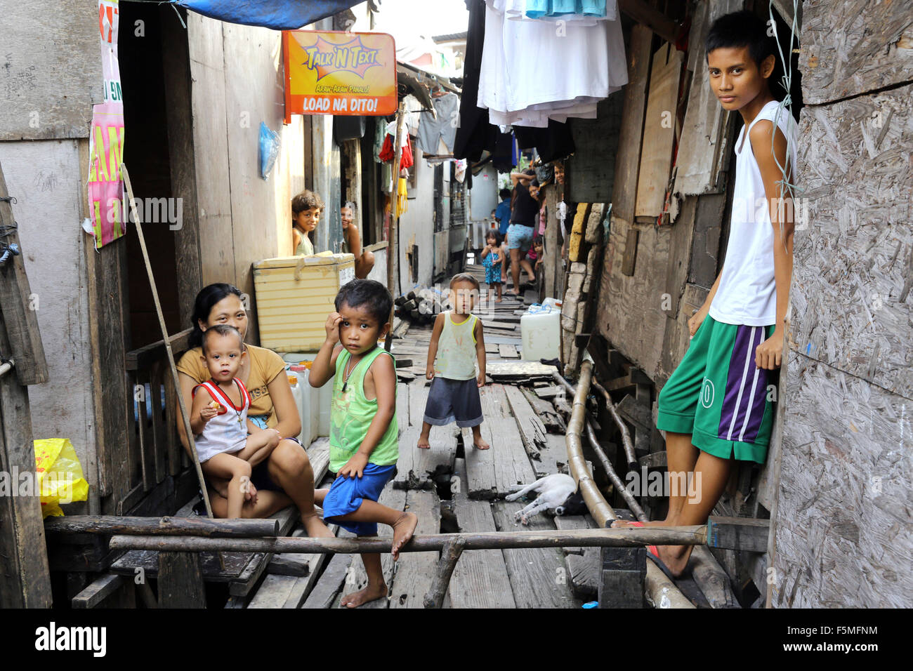 Manila, The Philippines: Resident of a poor neighborhood living in huts on stilts above water, Tondo township, Manila, Philippines Stock Photo