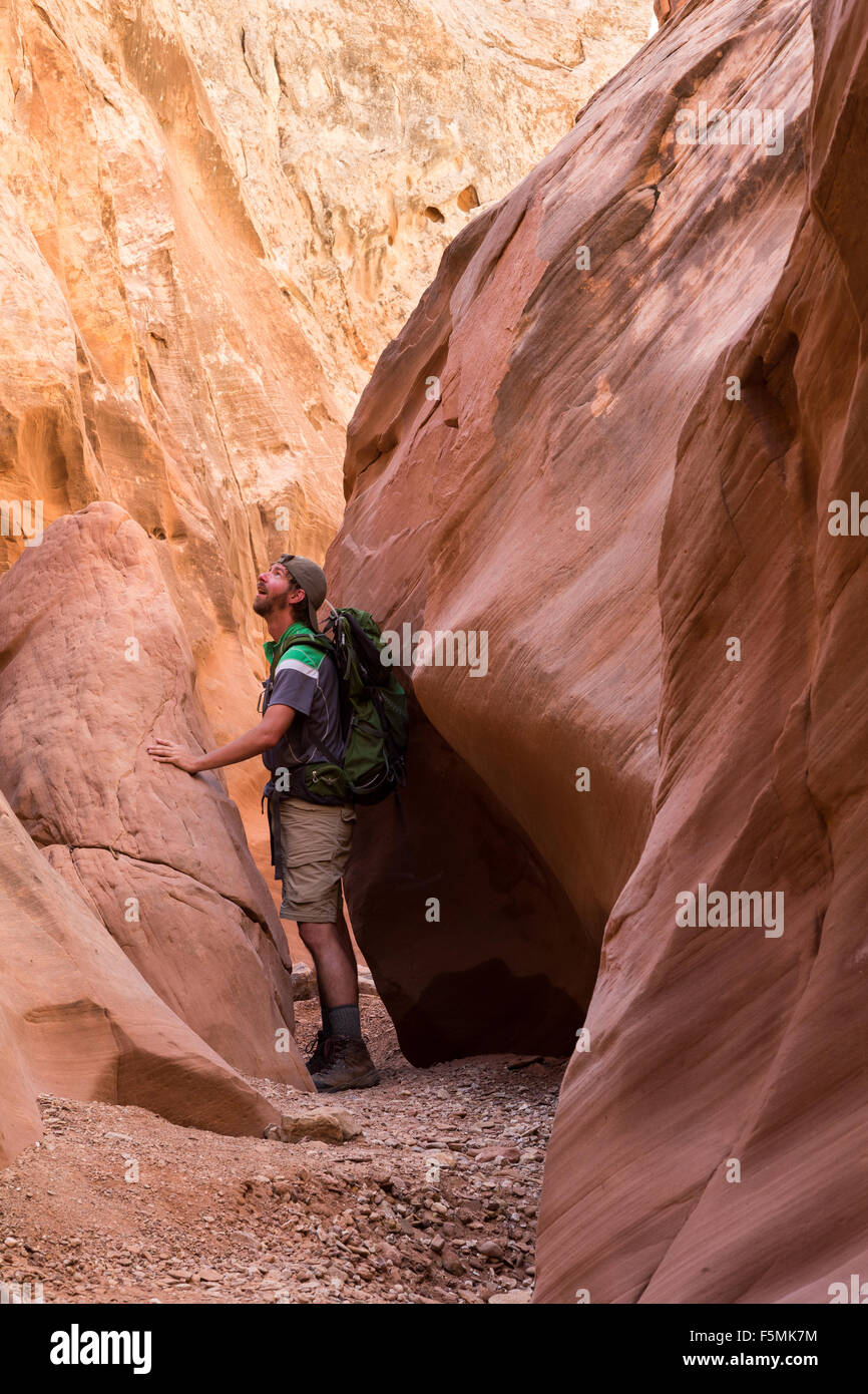 A hiker passing through a slot canyon in Bell Canyon, San Rafael Swell