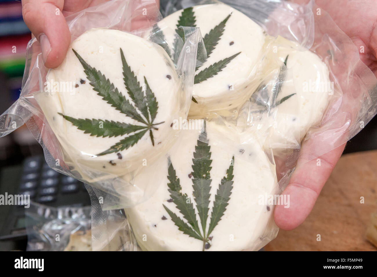 Sheep's cheese vacuum-packed, decorated with a cannabis leaf Prague Czech Republic Family farm product A man offers a product Stock Photo