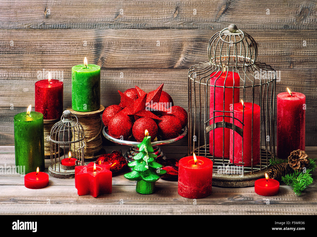 Christmas decoration with burning candles and red baubles. Nostalgic home interior Stock Photo