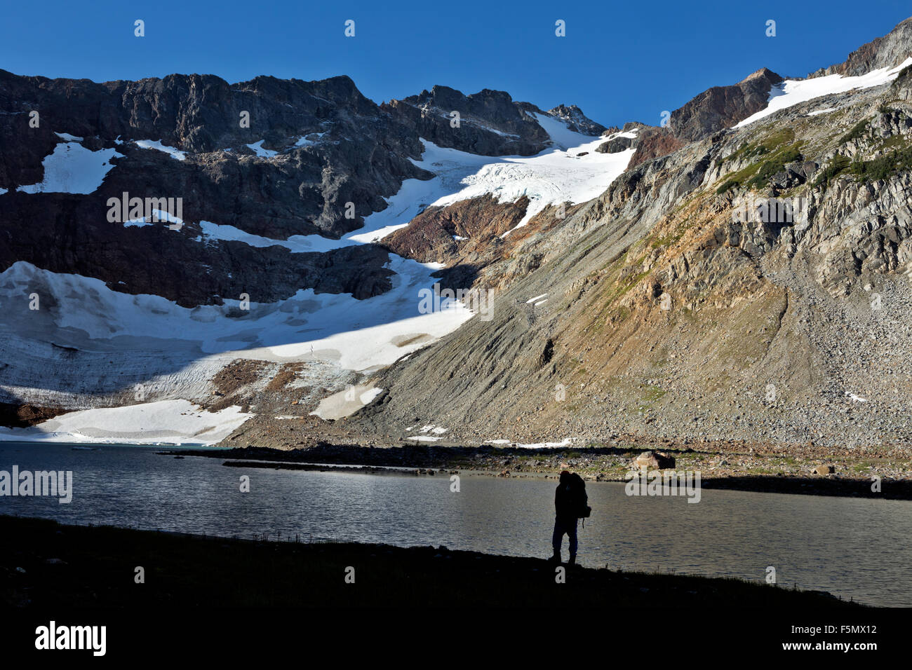 WASHINGTON Backpacker at Upper Lyman Lake below the Lyman Glacier and