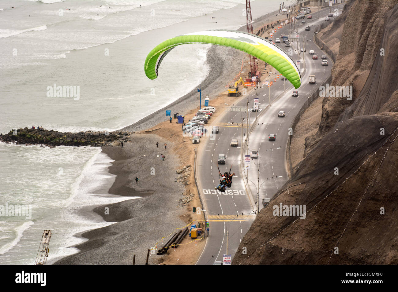 Tourist paragliding off the Larcomar seafront area of Lima city in Peru overlooking the pacific ocean and Costa Verde highway Stock Photo