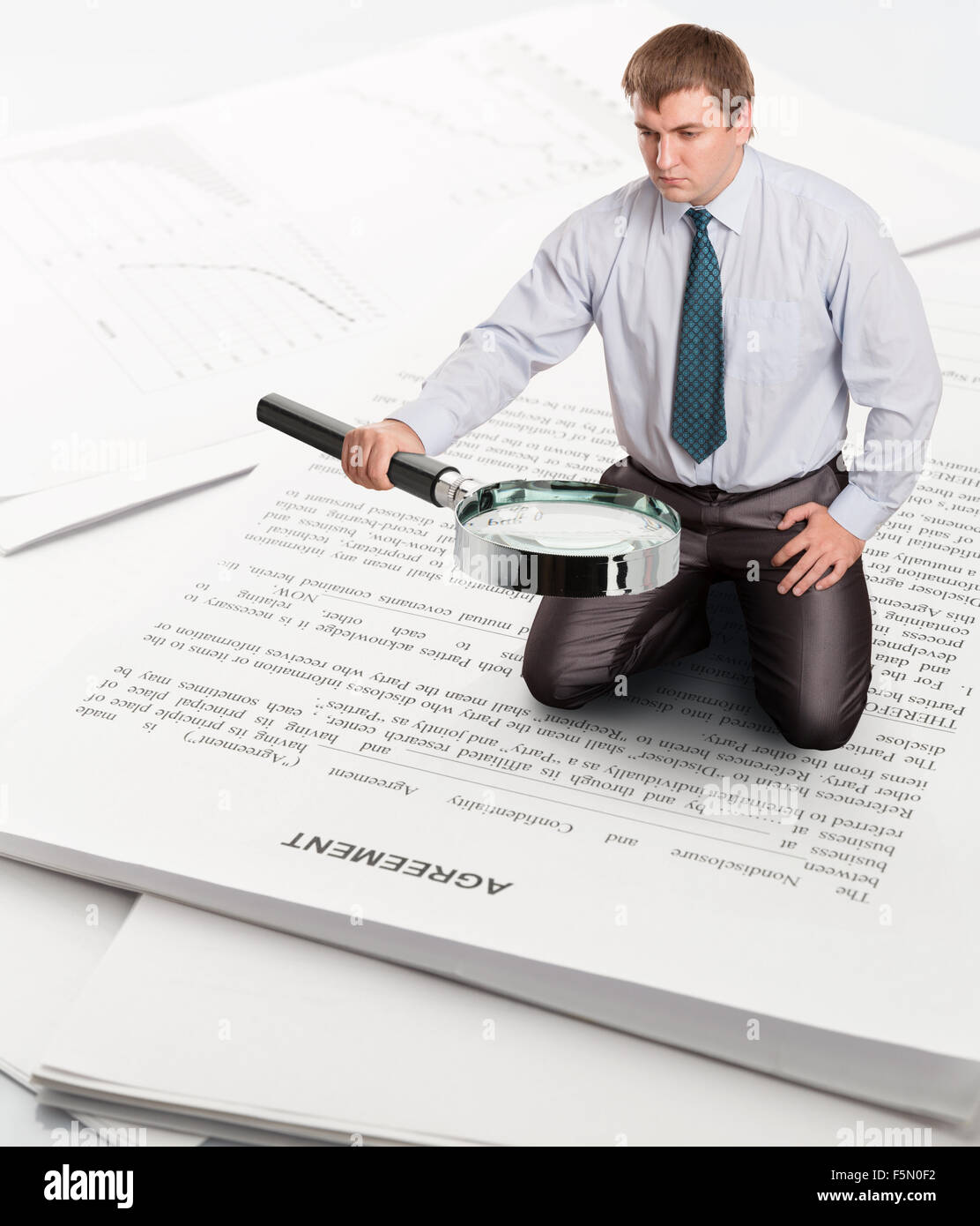 Man with big loupe sits on papers and finds something Stock Photo - Alamy