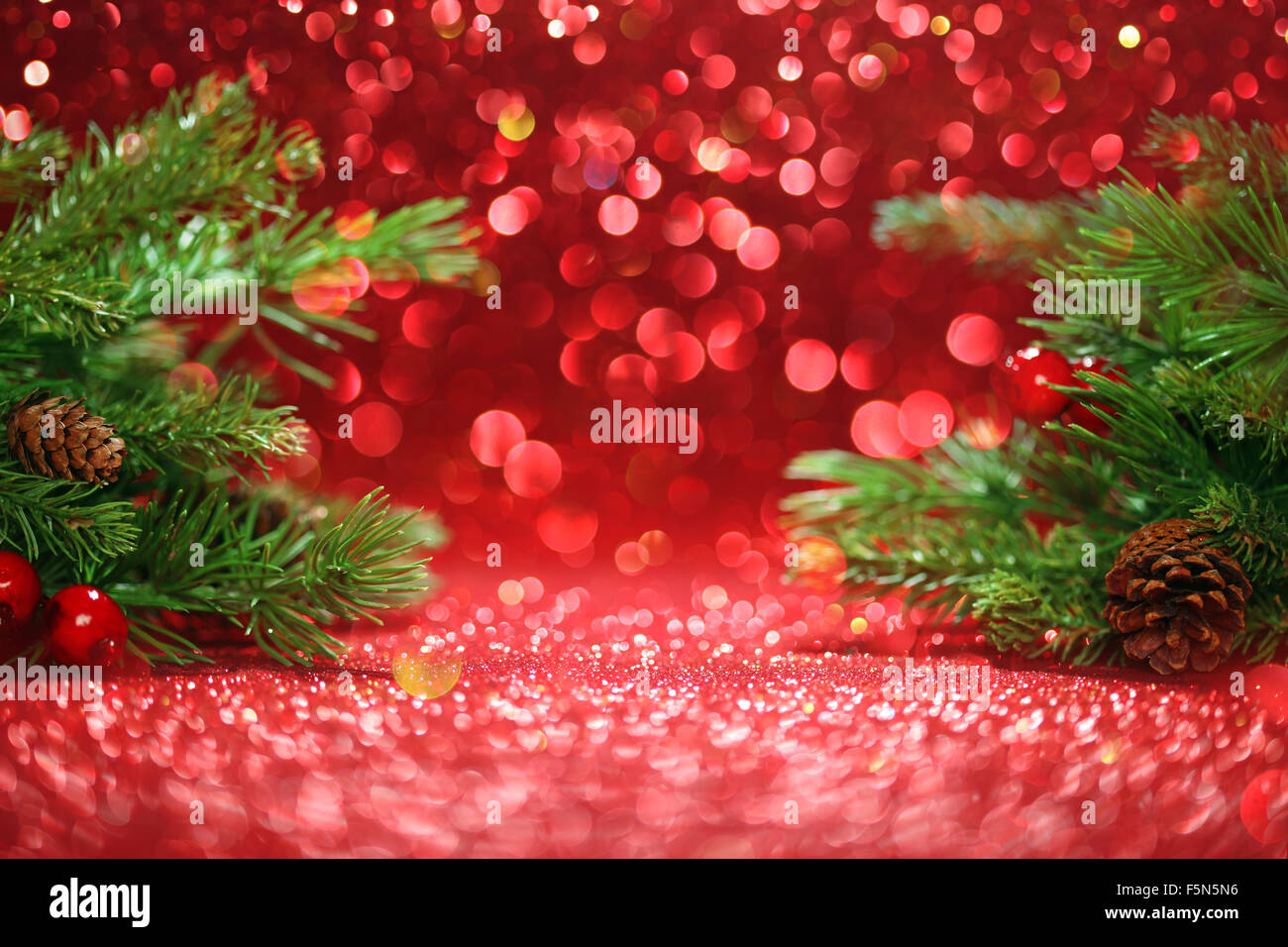 Christmas tree branches on glittering red background Stock Photo - Alamy