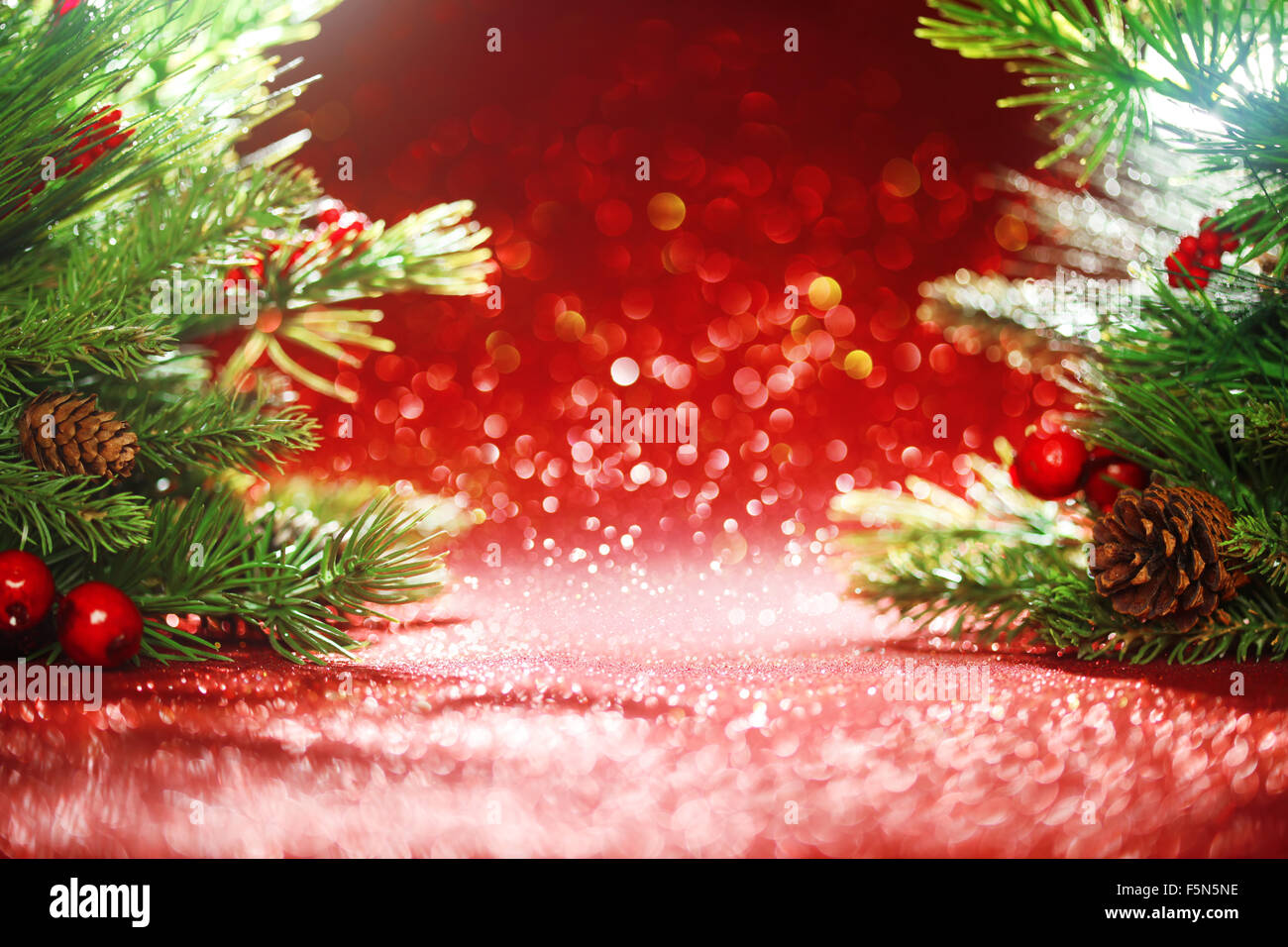 Christmas tree branches on glittering red background Stock Photo - Alamy