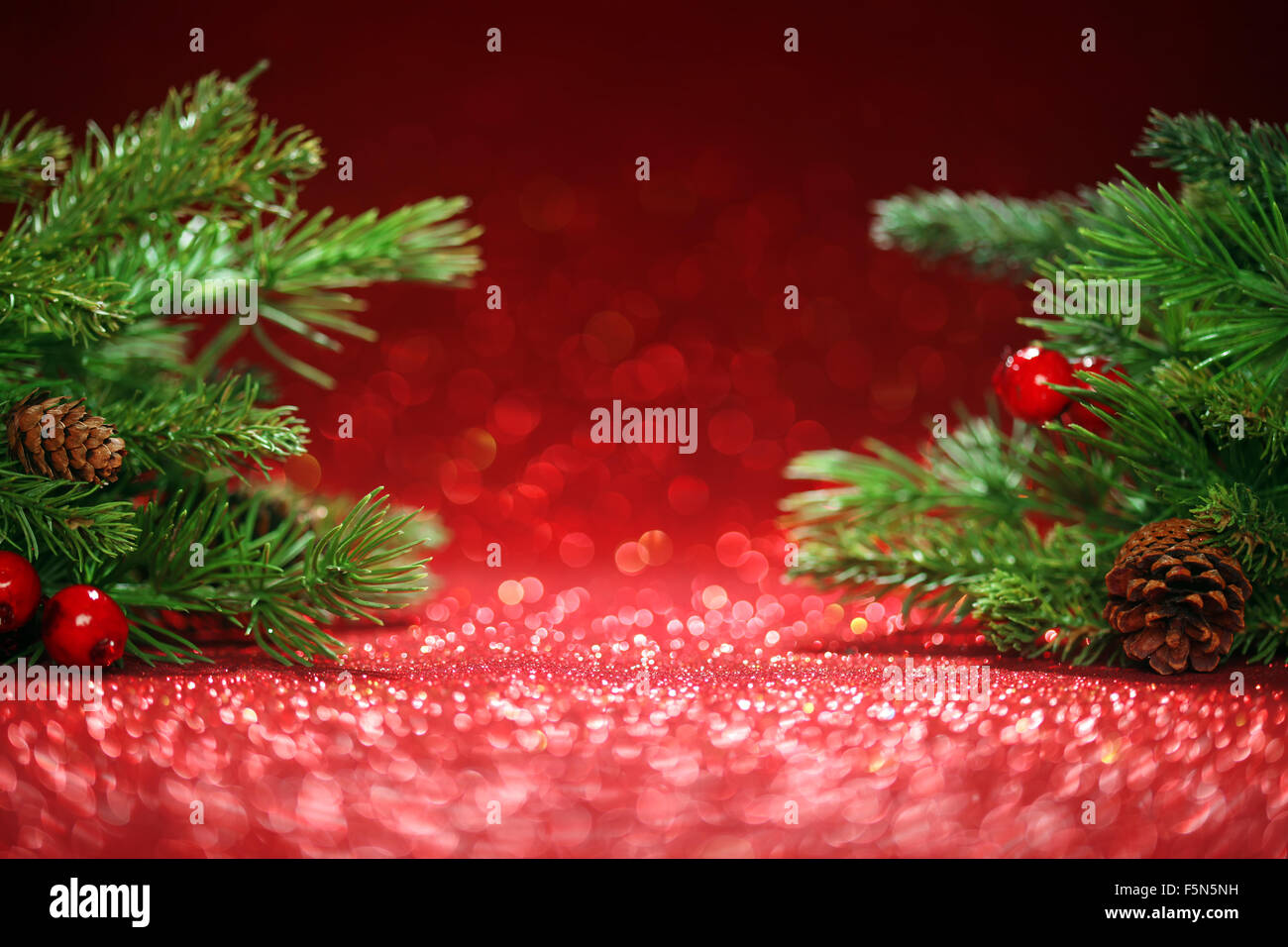 Christmas tree branches on glittering red background Stock Photo - Alamy