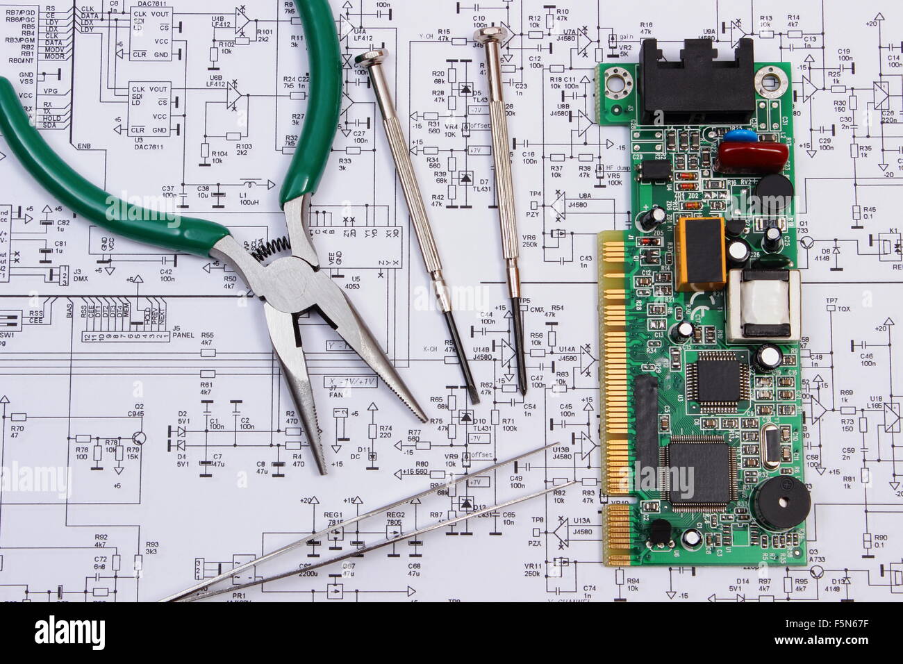 Printed circuit board with electrical components and precision tools lying  on construction drawing of electronics Stock Photo - Alamy