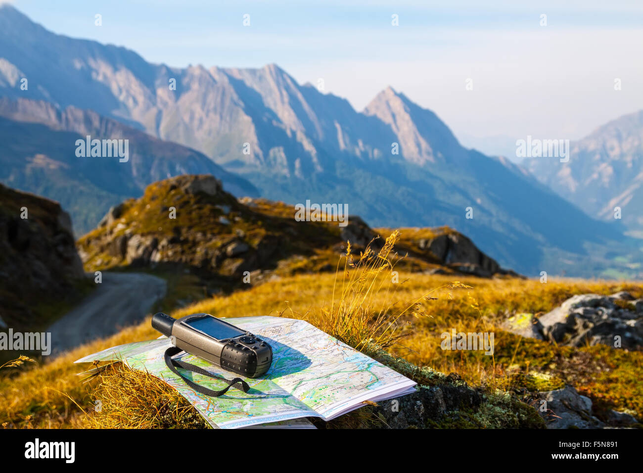 GPS navigator and map on Alps mountain background Stock Photo