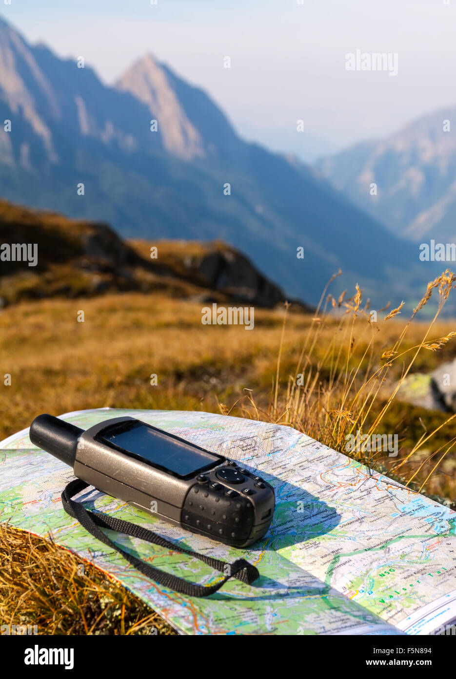 GPS navigator and map on Alps mountain background Stock Photo