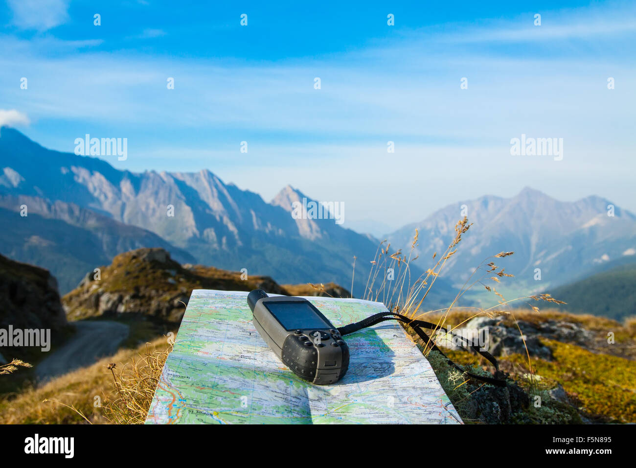 GPS navigator and map on Alps mountain background Stock Photo