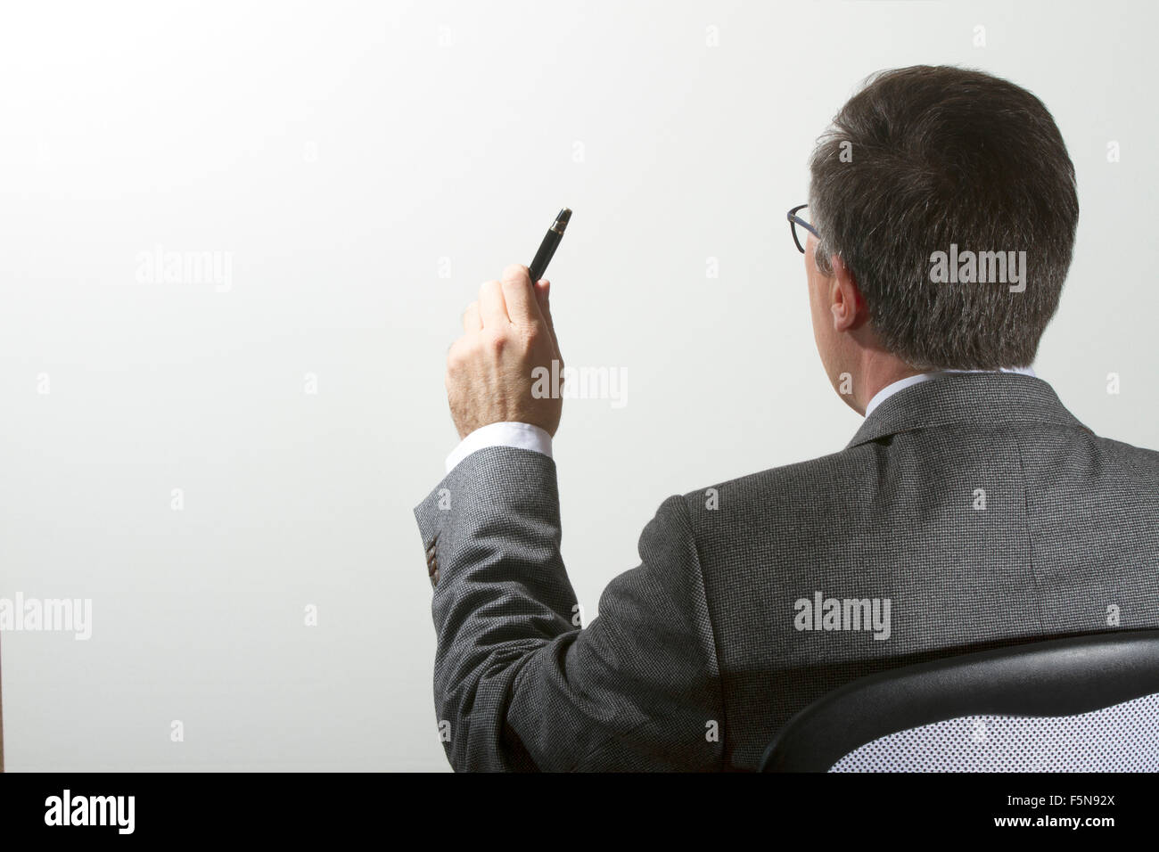 a middle age executive asking questions on a white background with free space for text Stock Photo