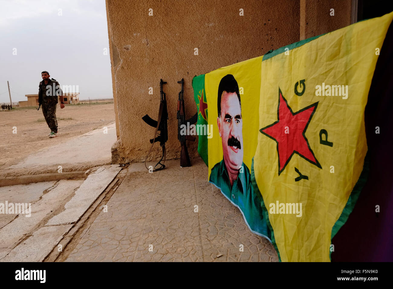 A flag bearing figure of former PKK militant leader Abdullah Ocalan is seen in a YPG Kurdish People's Protection Unit military compound in Al Hasakah or Hassakeh district or Rojava the de facto Kurdish autonomous region originating in and consisting of three self-governing cantons in northern Syria Stock Photo