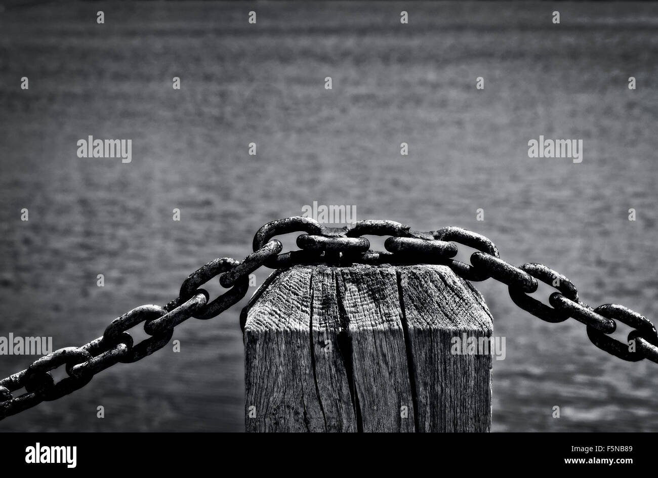 Chain link fence barrier by waterside Stock Photo