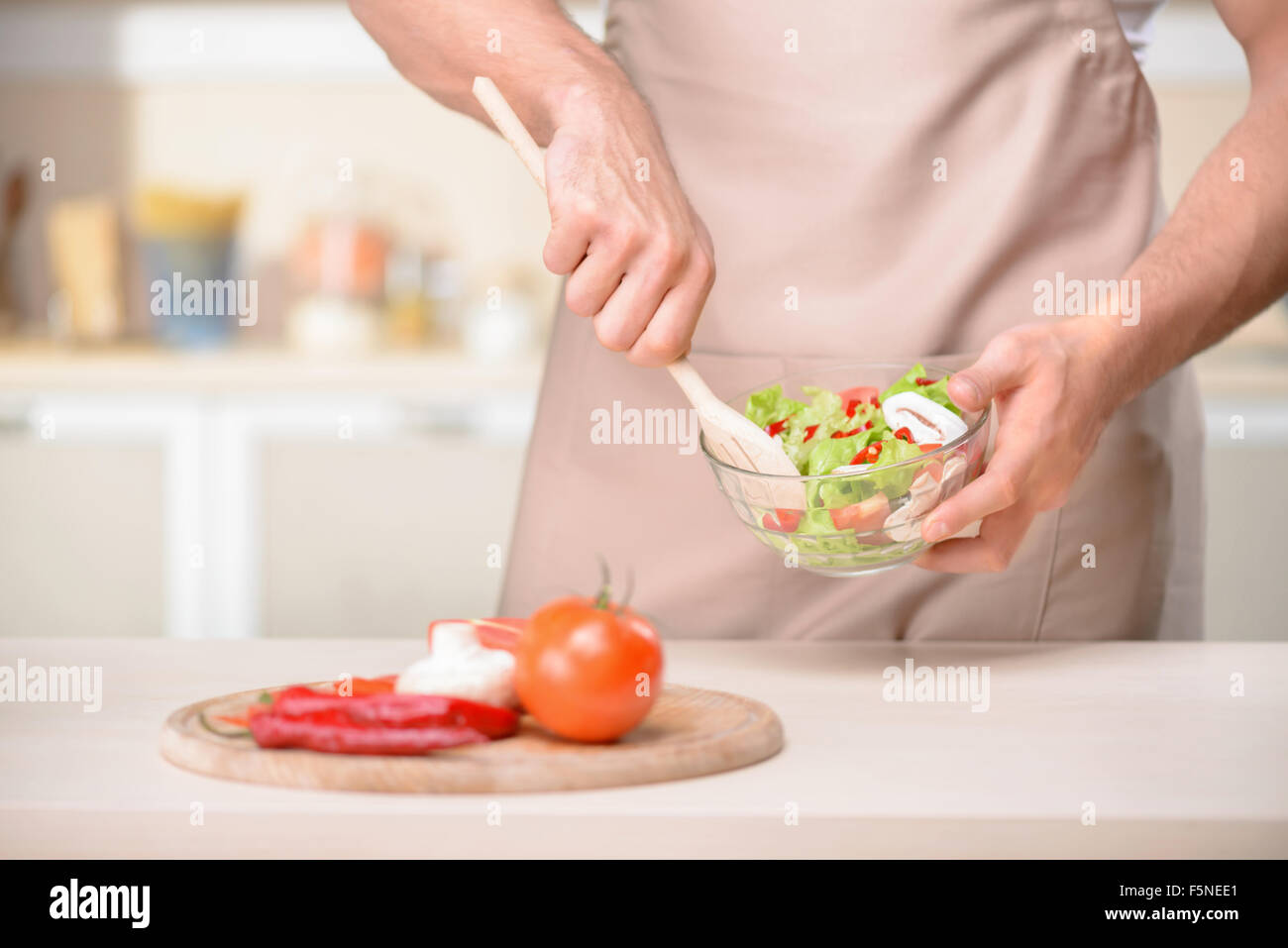 Young tough guy is mixing a salad Stock Photo Alamy