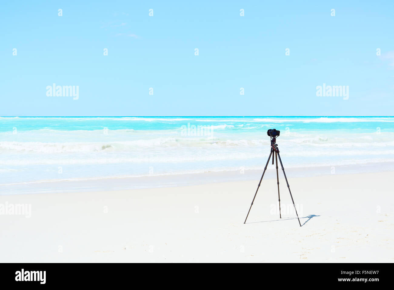 Digital Camera, tripod and filters on white beach ready for landscape photography Stock Photo